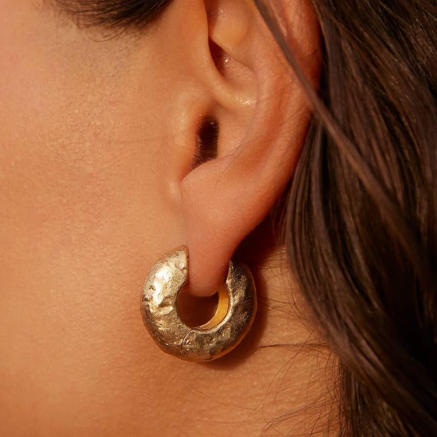 Close-up of ear with gold hoop earring.