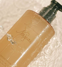 Close-up of a beige bottle with 'Mother Nature' branding on a textured background