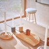 Set of ceramic candle holders on a wooden surface with a window in the background