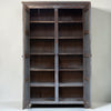 A tall, rustic wooden bookcase with two open doors and multiple shelves, shown against a plain off-white background.