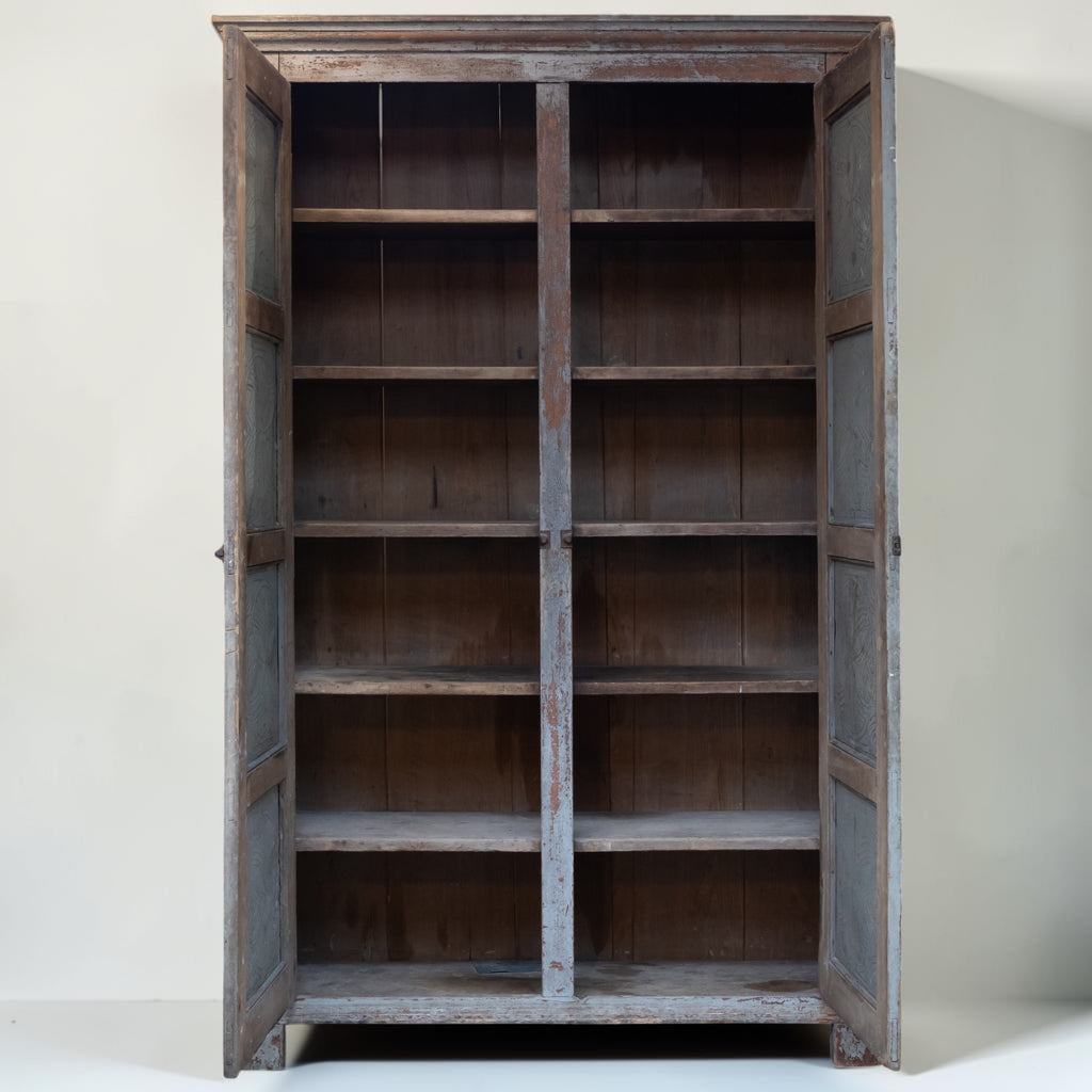 A tall, rustic wooden bookcase with two open doors and multiple shelves, shown against a plain off-white background.