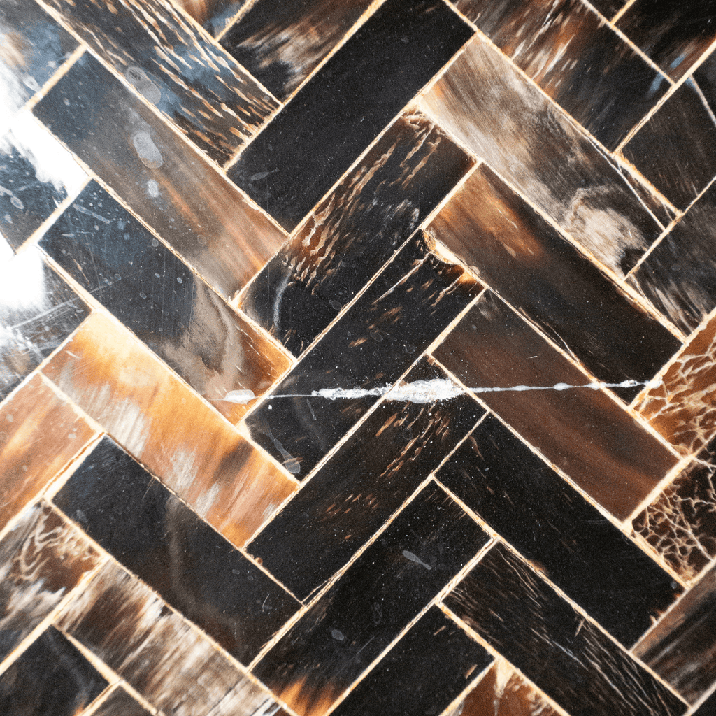 Herringbone pattern of dark brown and tan rectangular tiles.