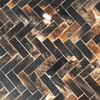 Herringbone pattern of dark and light brown rectangular tiles.