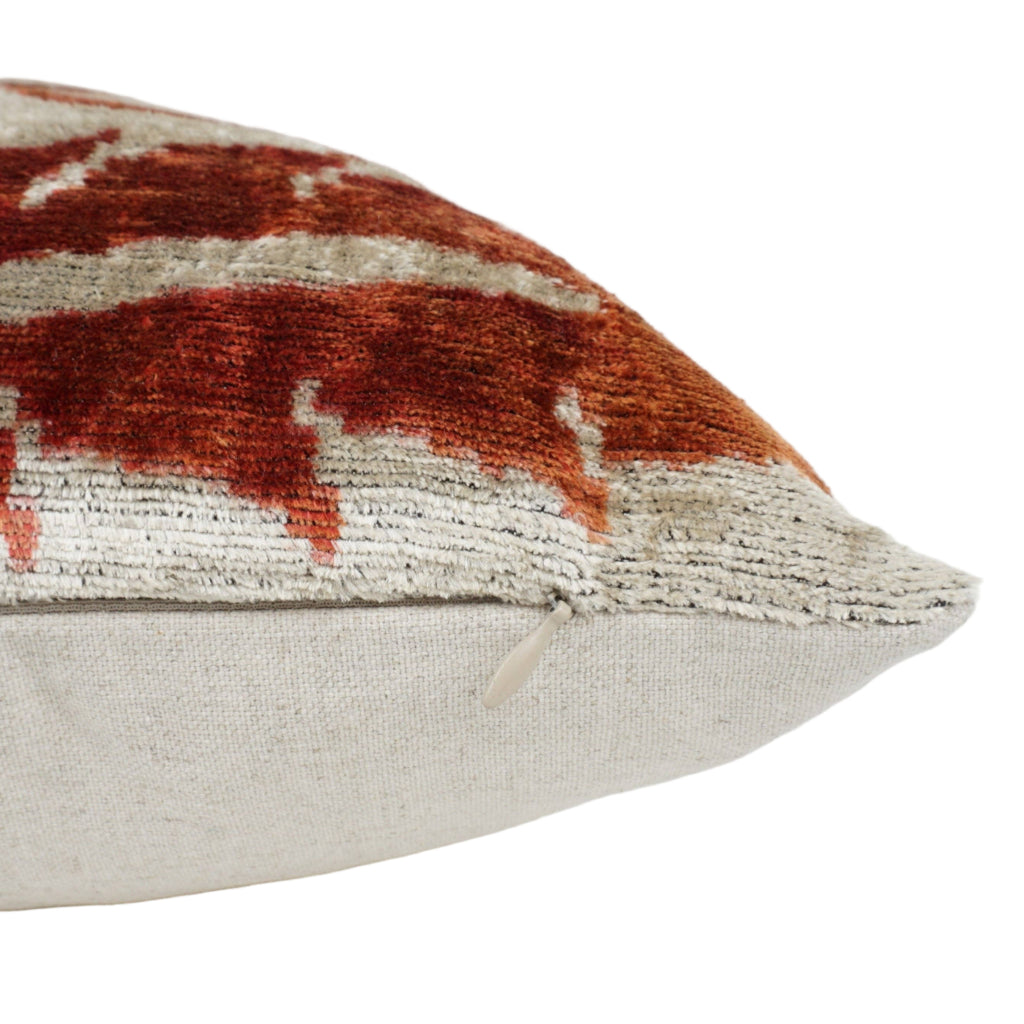 Close-up of an orange and cream patterned pillow.