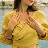 Woman in yellow shirt with jewelry.