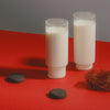 Two glasses of milk on a red surface with a gray background