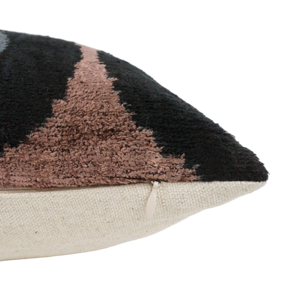 Close-up of a decorative black pillow with abstract pattern.