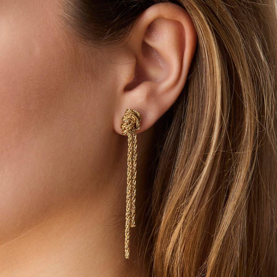 Gold earring worn by a person with long hair