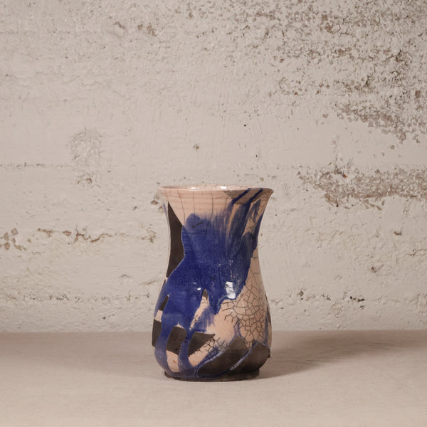 Ceramic vase with abstract design against a textured wall