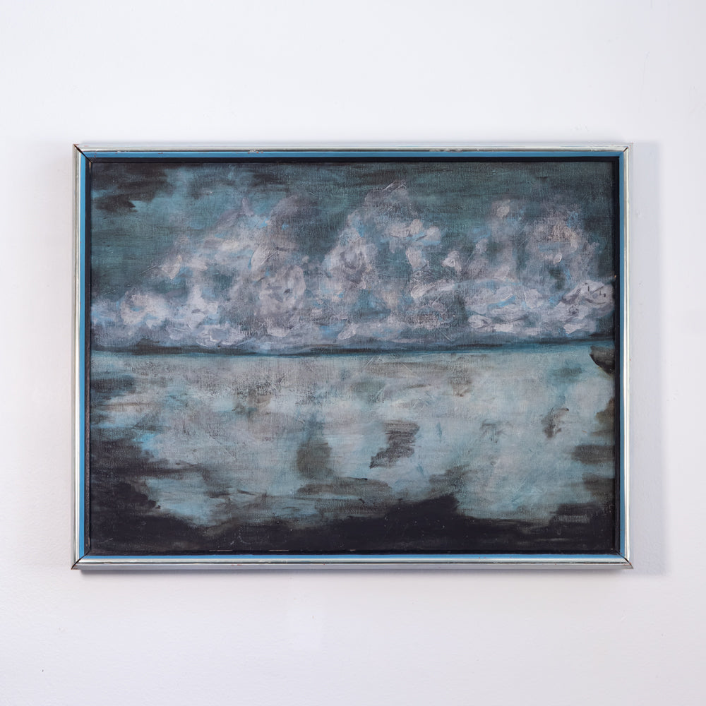 A framed landscape painting depicting a cloudy sky and water reflection, mounted on a plain white wall.