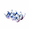 Speckled blue and white ceramic egg holder on a pink background