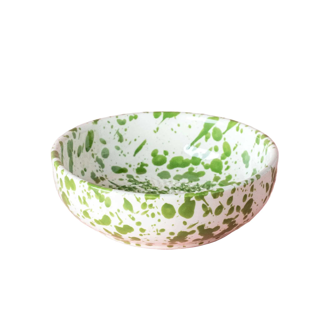 Green and white speckled bowl on a pink background