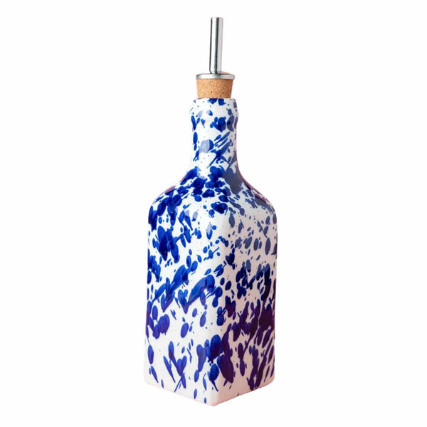 Blue and white ceramic bottle with a straw on a pink background