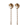 Two silver spoons with twisted handles on a beige background