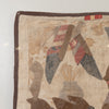 A close-up of a vintage patchwork quilt showing a beige linen base with brown borders and various fabric patches in muted tones of red, gray, and brown.