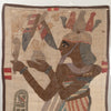 An ancient Egyptian-style textile artwork or tapestry on a beige linen background, featuring a stylized figure in brown tones with red, blue, and gray details, bordered by a dark brown edge.