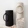 Big Ring Raw Handmade Ceramic Vase - Black + White displayed on stone pillars 