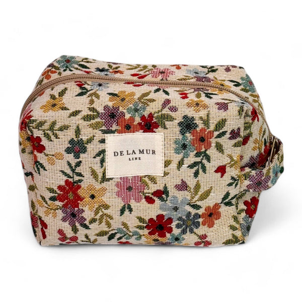 Floral patterned cosmetic bag with 'De Lamar' label on a white background