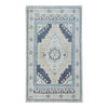 A rectangular area rug with a traditional medallion pattern in beige, light blue, and navy, shown flat against a white background.