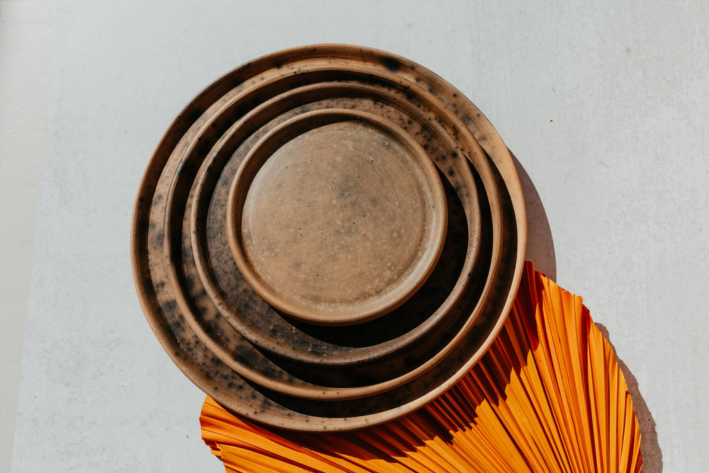 Brown Reactive Glaze Plates set displayed with orange leaf 