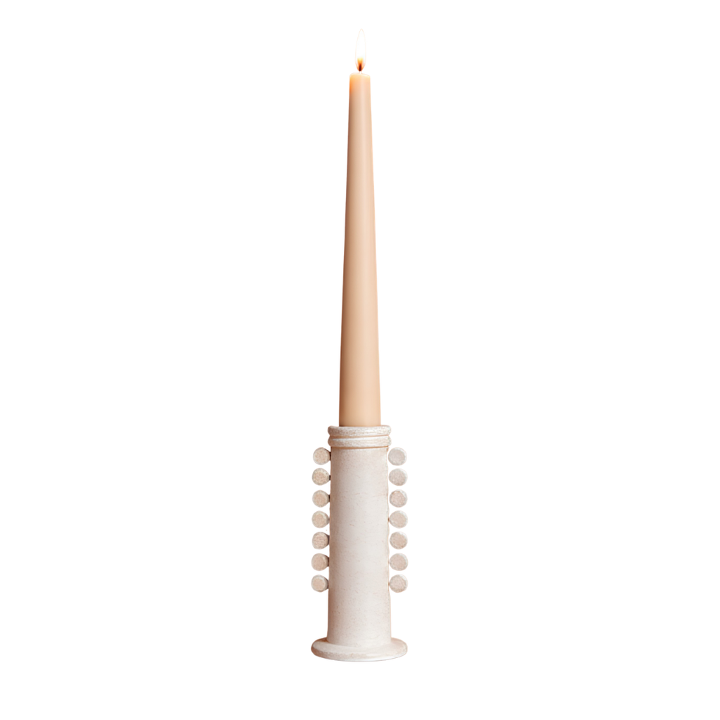 A tall, slender cream candle in a matching cylindrical holder with decorative bead-like accents, shown against a plain white background.