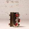 A vintage silver-toned cuff bracelet decorated with red cabochon stones and silver-toned metal accents, displayed on a light textured surface.