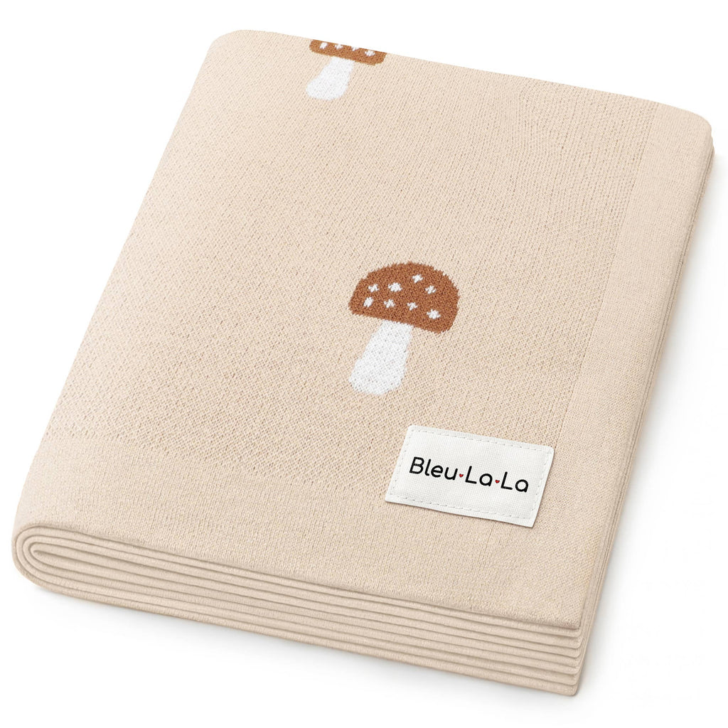 Beige blanket with mushroom design and 'Bleu Lo La' label on a white background