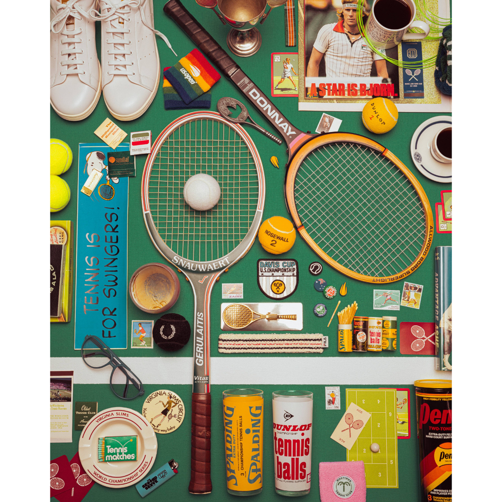 A flat-lay collage of tennis-themed items on a green background, including two vintage-style tennis rackets, tennis balls, shoes, a trophy, cups, stickers, and branded packaging. Visible brands include Donny, Wilson, and Penney.