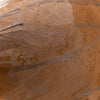 Close-up of a terracotta clay surface with a glossy, wet sheen and visible horizontal metallic silver lines.