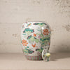 Decorative ceramic jar with floral patterns on a textured surface