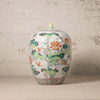 Decorative ceramic jar with floral patterns on a textured surface