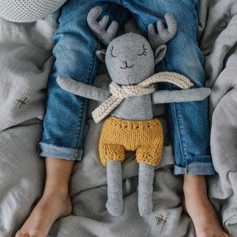 Felix Deer stuffed animal lying with a child in bed 