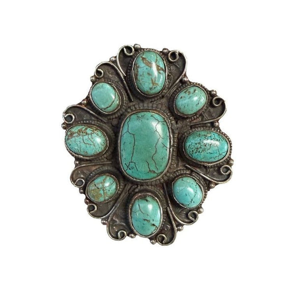 Turquoise stone brooch on a white background