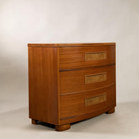 A mid-century modern wooden chest of drawers with three curved front drawers, featuring decorative inlaid floral panels on the drawer fronts and a warm medium-brown wood finish, set against a neutral light gray background.