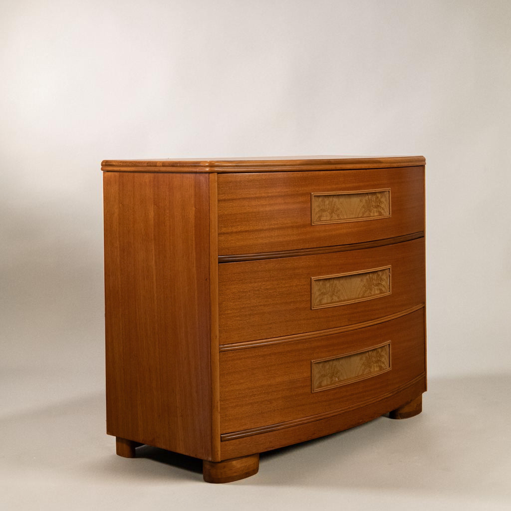 A mid-century modern wooden chest of drawers with three curved front drawers, featuring decorative inlaid floral panels on the drawer fronts and a warm medium-brown wood finish, set against a neutral light gray background.