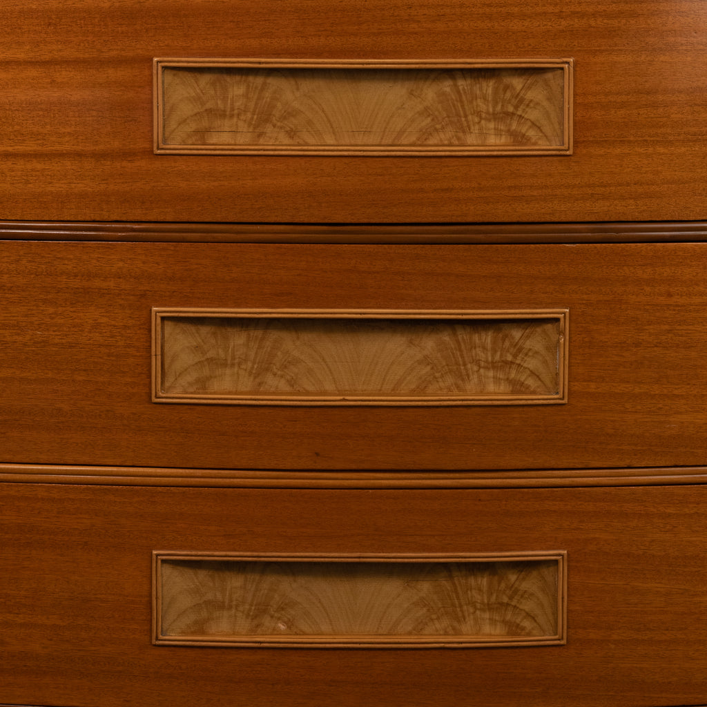 Close-up of a wooden chest of drawers showing three drawers with rectangular glass-front fronts and decorative inlay.