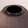 Close-up of a dark brown ceramic vase with a textured, hand-painted finish and a glossy glazed rim, showing the top opening against a neutral light background.