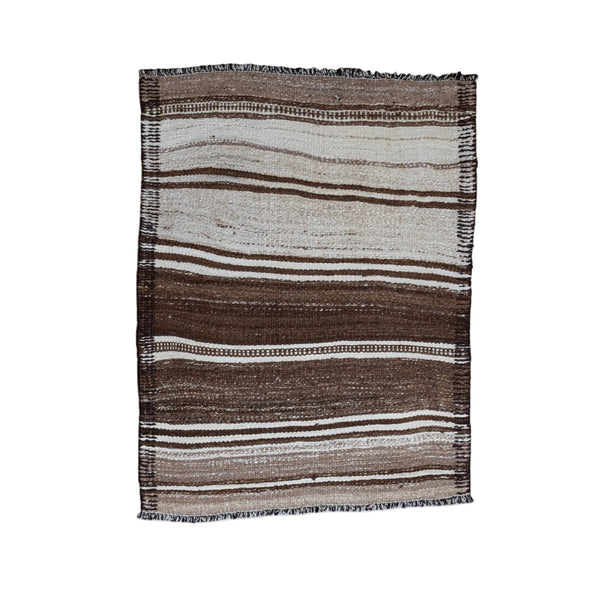 A rectangular woven placemat with vertical stripes in brown, beige, and white, featuring fringed edges, displayed flat against a plain off-white background.