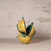 Yellow ceramic bowl with green accents on a textured surface