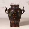 An antique Japanese enamel vase with dragon handles, featuring a dark bronze-brown base with vibrant green, blue, and gold decorative details.