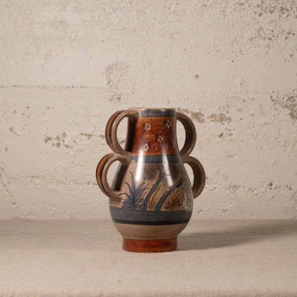 Ceramic vase with floral patterns on a textured surface and background