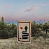 Textile with a snake design in a desert landscape
