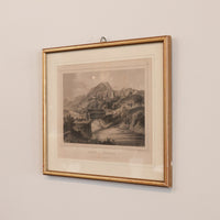 Framed black and white landscape print on a beige wall
