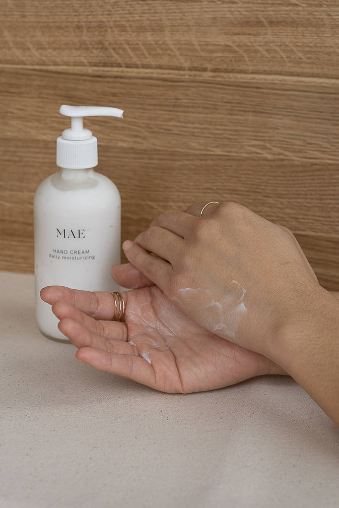 MAE Hand cream displayed with 2 hands applying lotion 