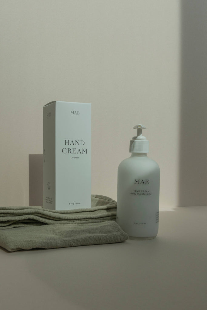 MAE Hand cream box and bottle displayed on a towel 