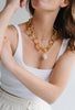 Maxi Emmie Necklace being modeled by a woman wearing white 