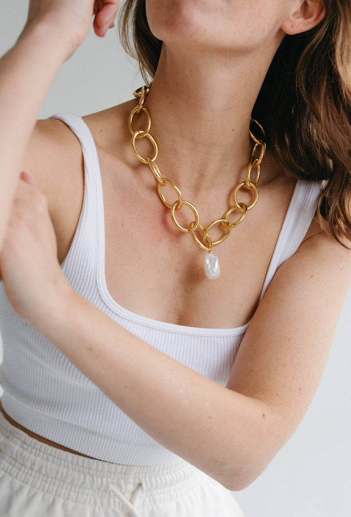 Maxi Emmie Necklace being modeled by a woman wearing white 