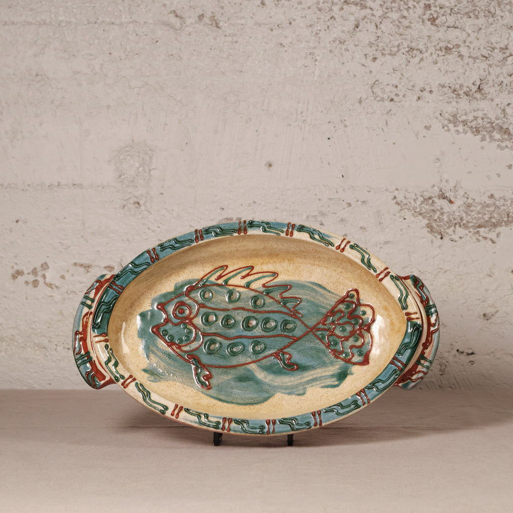 Ceramic platter with fish design on a textured surface