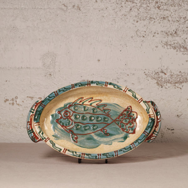 Ceramic platter with fish design on a textured surface