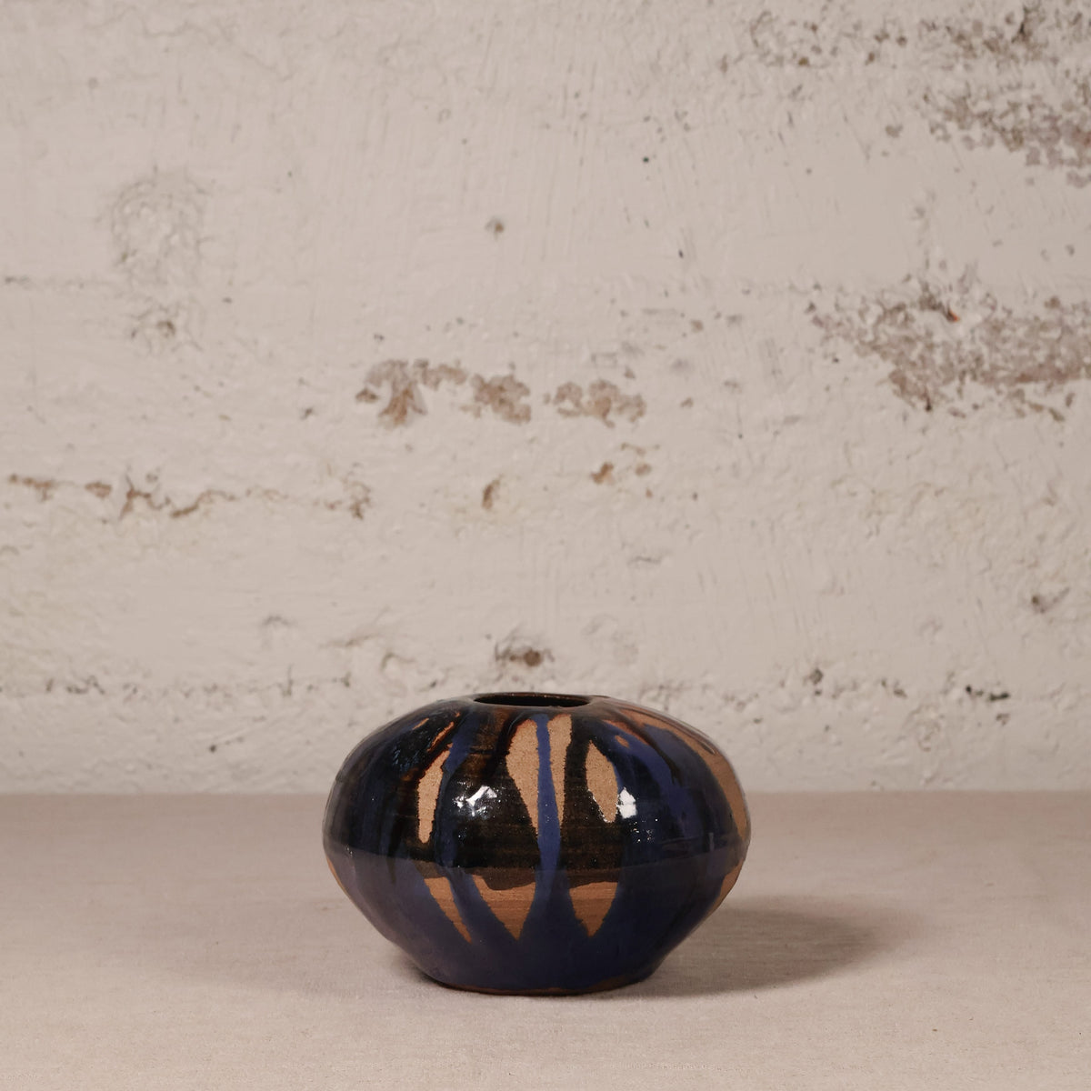 Ceramic vase with abstract design on a textured surface